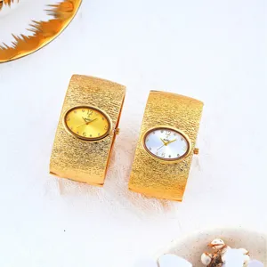 Reloj de pulsera ancho dorado de lujo con esfera ovalada y acabado texturizado