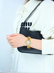 Close up detail shot of luxury gold chain rhinestone women wrist watch on elegant wrist.