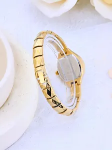 Luxury gold tonneau women watch with faceted geometric bracelet, vintage elegant timepiece.