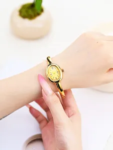 Gold oval quartz watch for women, stylish minimalist bangle wrist watch with Roman numerals.