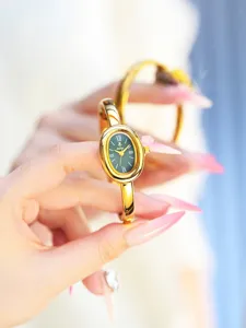 Elegant gold oval quartz watch for women featuring green dial and stylish vintage bangle design.