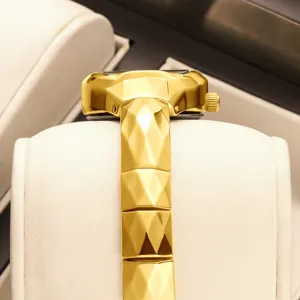 Gold tonneau watch for women, luxury faceted metal strap design, elegant vintage timepiece.