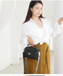 Detailed view of a chic black quilted shoulder bag with golden heart hardware and strap.