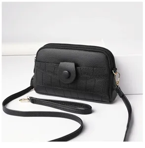Close-up detail view of a black textured mini crossbody bag with phone pouch and strap.
