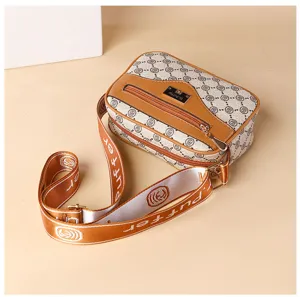 Detailed view of stylish crossbody shoulder bag with retro pattern and wide strap.