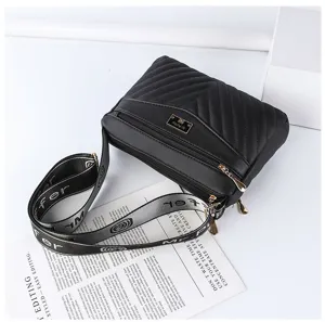Detail view of black quilted women's shoulder bag with wide strap and chevron design.