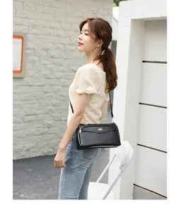 Detailed view of a stylish black PU leather crossbody shoulder bag with cute bow detail.