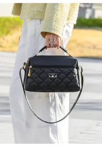 Detailed view of the black quilted leather crossbody handbag, showing hardware and fine texture.