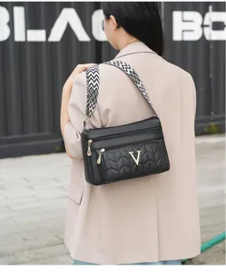 Black soft leather shoulder bag for women, multi zipper crossbody bag with patterned strap.