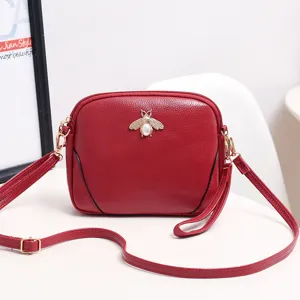 Bolso bandolera de piel roja con abeja dorada y perla para estilo de moda mujer elegante diario.