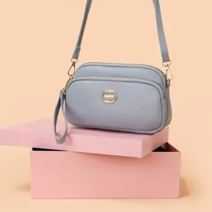 Elegant women's multi-pocket crossbody bag in soft grey PU leather with gold tone hardware.