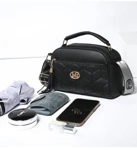 Close-up detail view of a chic black quilted crossbody bag with stylish strap and gold hardware.