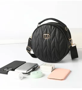 Detailed view of black quilted round cross-body bag showcasing texture and capacity.