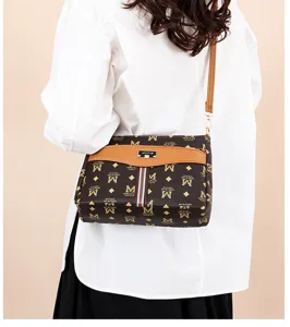 Detailed view of women's brown monogram crossbody bag with stripe detail and adjustable strap.
