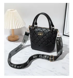 Detailed shot of a black quilted leather handbag with chic strap and metal logo accent.