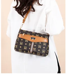 Winter women's brown monogram crossbody bag with M print, adjustable strap and front pocket.