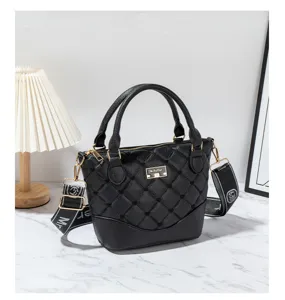 Detailed view of black quilted leather handbag with wide strap and chic metal hardware.