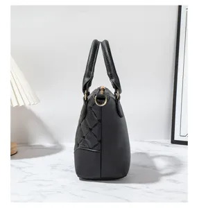Black quilted leather handbag side detail, premium top handle design with gold hardware accents.