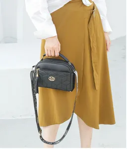 Detail shot of the black quilted crossbody bag featuring elegant diamond pattern and shoulder strap.