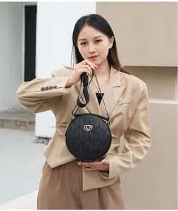 Classic black round quilted crossbody bag with stylish wide strap and gold heart hardware.