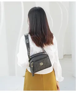 Stylish women black quilted crossbody shoulder bag with patterned strap and metal decor.