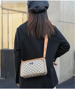 Detail view of the stylish crossbody shoulder bag with monogram pattern and adjustable strap.