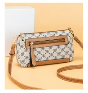 Detail view of vintage monogram crossbody bag with brown leather trim and zipper pocket.