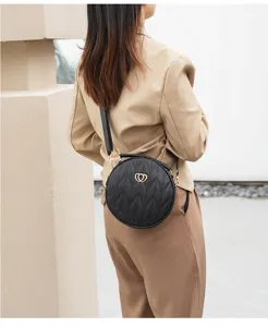 Detailed view of the elegant black round quilted crossbody bag with stylish heart clasp.