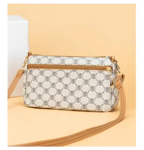 Detailed view of women's vintage monogram crossbody bag with brown leather trim and zipper.