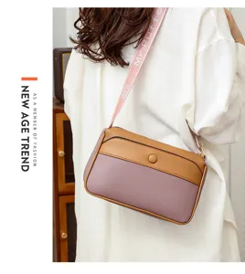 Stylish women's color-block crossbody shoulder bag with unique printed strap detail.
