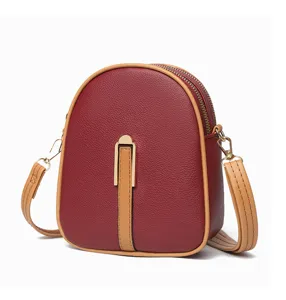 Close-up of the vertical small crossbody phone bag with wine red PU leather and gold hardware.