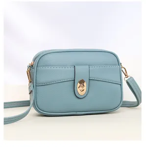 Close-up detail of the light blue crossbody bag showcasing premium leather texture and hardware.