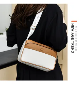 Detail view of stylish color-blocked women shoulder bag with wide strap and fashion print.