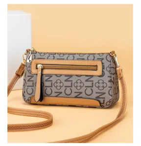 Detailed view of vintage monogram crossbody shoulder bag with tan leather trim and hardware.