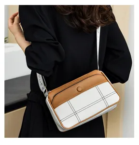 Stylish two-tone crossbody shoulder bag with patterned strap, detailed view of texture and design