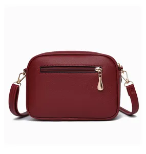 Detailed view of wine red PU leather minimalist crossbody bag with gold hardware and back zipper.