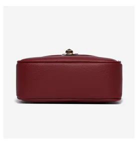 Red leather crossbody bag bottom detail, minimalist style women fashion handbag texture view.