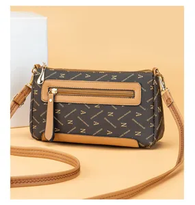 Vintage monogram crossbody bag for women with front zipper pocket and tan trim.
