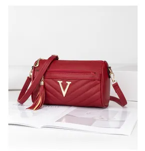 Red quilted crossbody shoulder bag with gold V logo and chic tassel charm for modern women.