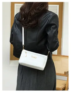 Vista di dettaglio della elegante borsa a tracolla da donna con motivo coccodrillo bianco.