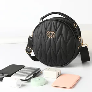 Black round quilted crossbody bag with stylish heart metal decor and comfortable wide strap.