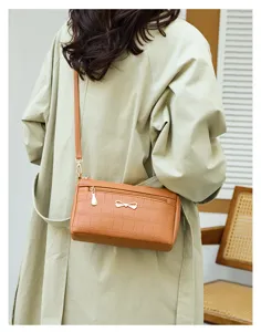 Borsa a tracolla marrone con motivo coccodrillo da donna con dettaglio fiocco in metallo.