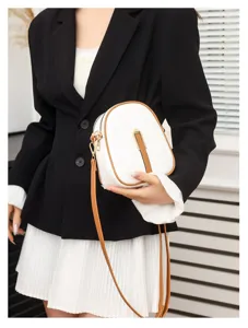Detail view of stylish white and brown vertical phone crossbody bag with chic clasp.