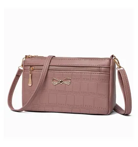 Elegante borsa a tracolla da donna con motivo coccodrillo e dettaglio fiocco in metallo.