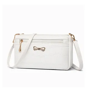 Borsa a tracolla bianca da donna con elegante motivo coccodrillo e grazioso fiocco chic.