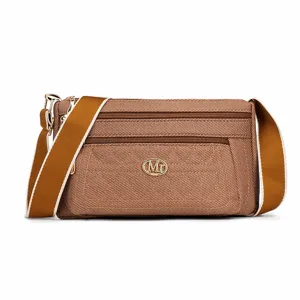 Élégant sac bandoulière en toile pour femme avec compartiments zippés pour usage quotidien.