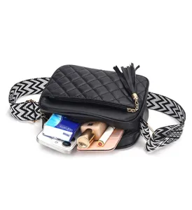 Black quilted crossbody bag detail showing interior capacity, wide strap and chic tassel charm.