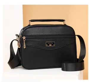 Close-up detail of the black PU leather crossbody bag showing metal zipper and brand plaque.