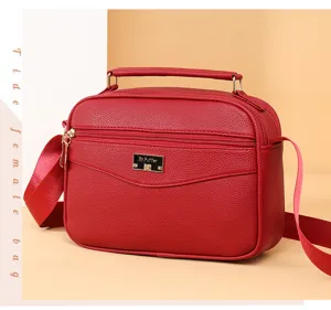 Red PU leather small square handbag detail shot, featuring top handle and adjustable strap.