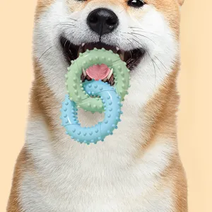 Close-up detail of dog biting dual ring TPR teething toy with textured spikes for clean teeth.